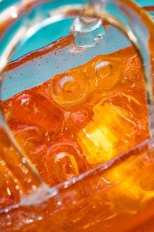 Gros plan sur un cocktail ambré avec glaçons servi à La Cabane Meudon, restaurant convivial en forêt à Meudon