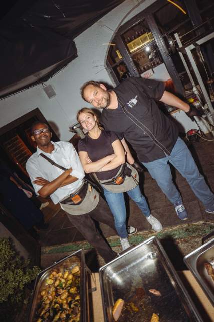 Équipe de cuisine de La Cabane Meudon dans les Hautes-de-Seine posant devant un buffet chaud en extérieur, ambiance conviviale en soirée