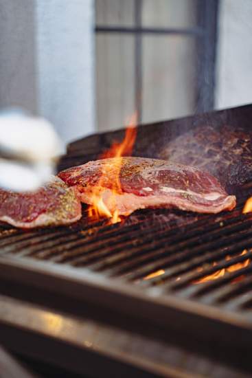 Cuisson de viandes au barbecue à La Cabane Meudon, restaurant en forêt proposant des soirées barbecue à Meudon