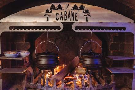 Cheminée de La Cabane Meudon avec marmites suspendues, restaurant en forêt idéal pour les soirées raclette et d’hiver à Meudon