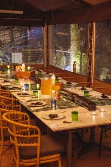 Grande table conviviale dressée à La Cabane Meudon pour un repas ou un événement, restaurant chaleureux en forêt à Meudon