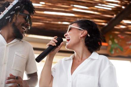 Clients chantant au micro lors d’une soirée à thème à La Cabane Meudon, restaurant convivial en forêt à Meudon