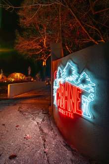 Enseigne lumineuse de La Cabane Meudon de nuit, restaurant et lieu événementiel en pleine forêt à Meudon