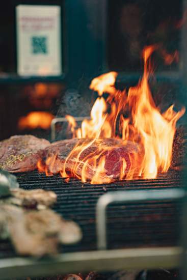 Cuisson de viande au barbecue à La Cabane Meudon, restaurant en forêt proposant des soirées barbecue à Meudon