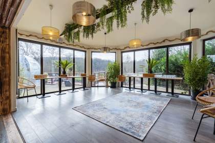 Salle lumineuse de La Cabane Meudon avec vue sur la forêt, espace événementiel du restaurant à Meudon