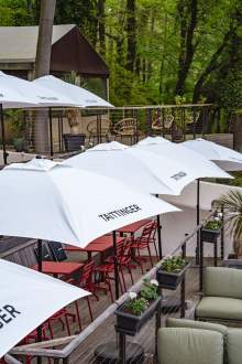 Table de terrasse de La Cabane Meudon avec parasols rouges, restaurant en pleine forêt à Meudon