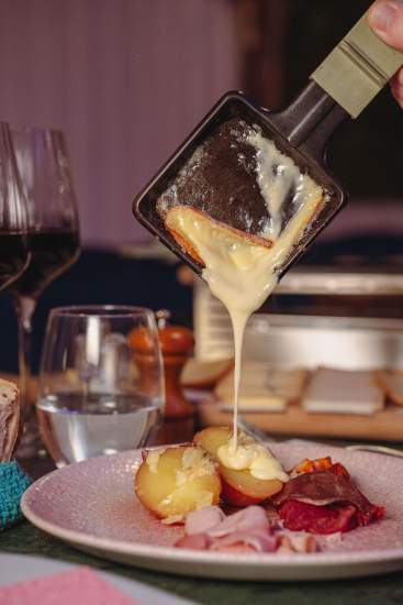 Fromage fondu servi lors d’une soirée raclette à La Cabane Meudon, restaurant convivial en forêt à Meudon
