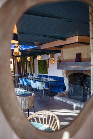 Salle intérieure de La Cabane Meudon avec cheminée et tables dressées, restaurant chaleureux en pleine forêt à Meudon