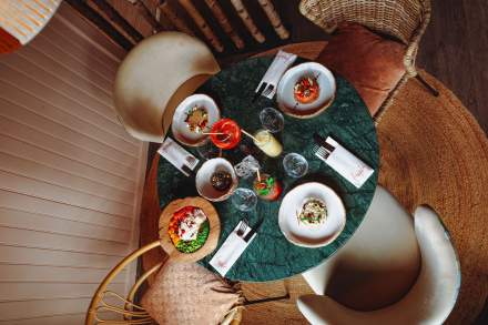 Table dressée vue du dessus avec plats et cocktails à La Cabane Meudon, restaurant convivial en pleine nature à Meudon