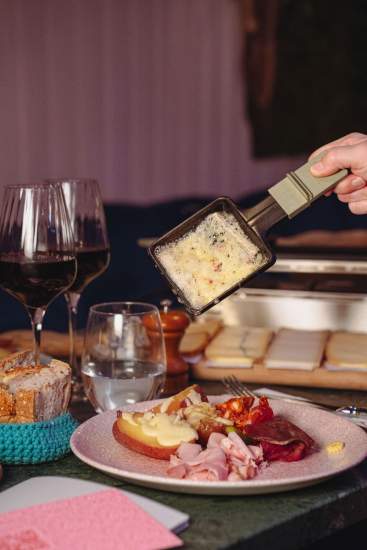Service de fromage fondu lors d’une soirée raclette à La Cabane Meudon, restaurant convivial en forêt à Meudon