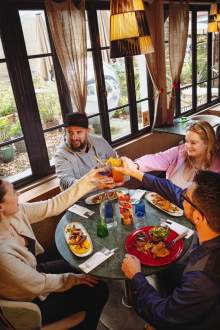 Groupe de clients partageant un repas convivial à l’intérieur de La Cabane Meudon, restaurant en pleine nature à Meudon
