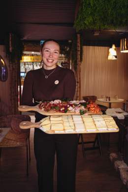 Serveuse présentant des plats au restaurant La Cabane Meudon, établissement convivial en pleine forêt à Meudon