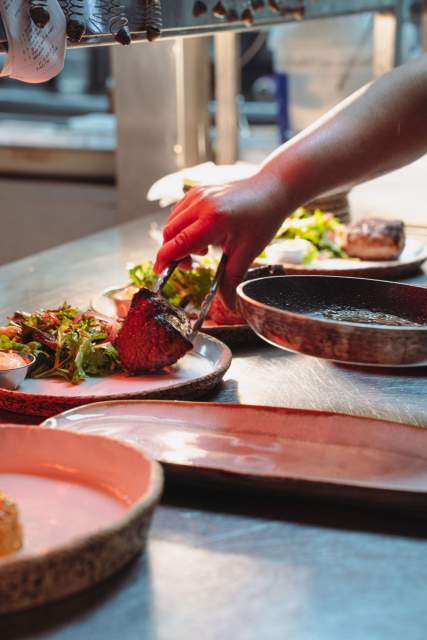 Dressage d’un plat en cuisine à La Cabane Meudon, restaurant traditionnel français proposant une cuisine de saison à Meudon