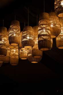 Suspensions lumineuses en osier à l’intérieur de La Cabane Meudon, restaurant chaleureux en pleine forêt à Meudon