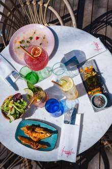 Table dressée avec plats et cocktails à La Cabane Meudon, restaurant convivial en pleine nature à Meudon